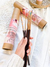 Load image into Gallery viewer, May include: A set of 16 therapeutic grade oil infused incense sticks in a brown cardboard tube with a pink floral design. The tube has text that reads "Therapeutic Grade Oil Infused Incense" and lists the scents: Rose & Frankincense, Rosemary & Lavender, Sage & Patchouli, Jasmine & Gardenia.
