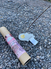 Load image into Gallery viewer, May include: A brown cardboard tube with a pink and white label that reads "Therapeutic Grade Essential Oil Based Incense Sticks" and lists the scents: Frankincense, Rosemary & Mint, Lavender & Chamomile, Sage & Patchouli, Jasmine & Clove. The tube is lying on a bed of small gray rocks. A gray ceram