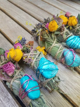 Load image into Gallery viewer, May include: Three bundles of dried sage wrapped in twine, each adorned with a bright turquoise stone secured by pink wire. The bundles are decorated with dried yellow rosebuds, pink rose petals, and small purple lavender sprigs.