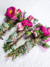 Load image into Gallery viewer, May include: Three bundles of dried herbs and flowers tied with twine and decorated with green stones. The bundles are made with rosemary, lavender, and pink flowers.
