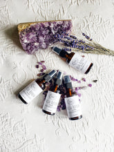 Load image into Gallery viewer, May include: Four amber glass bottles with spray tops and white labels. The labels read "Facial Refresh Lavender Charged Amethyst Crystals". The bottles are arranged on a white surface with purple amethyst crystals and dried lavender.