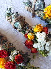 Load image into Gallery viewer, May include: Three bundles of dried herbs and flowers tied with twine. Each bundle includes a green stone, dried roses, and other dried flowers.