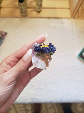 Load image into Gallery viewer, May include: A small, clear crystal with a purple hue, topped with a dried flower arrangement. The flower is a purple and yellow daisy with a brown center. The crystal is held in a hand.