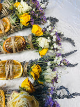 Load image into Gallery viewer, May include: Dried flower bundles with dried orange slices, yellow roses, and lavender. The bundles are tied with twine and are arranged on a white surface.