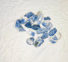 Load image into Gallery viewer, May include: A collection of blue and white sodalite crystal chips. The chips are rough and have a natural, unpolished look.
