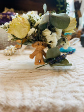 Load image into Gallery viewer, May include: A small, brown troll figurine with a green leafy crown of dried flowers, including white roses and eucalyptus.
