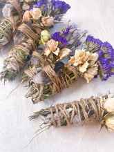 Load image into Gallery viewer, May include: Three bundles of dried herbs and flowers tied with twine, each containing a clear quartz crystal and a black obsidian stone. The bundles are arranged on a white surface.
