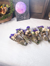 Load image into Gallery viewer, May include: A collection of six smudge sticks wrapped in twine and decorated with dried flowers. Each smudge stick has a clear quartz crystal at the end.
