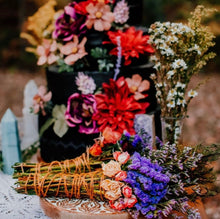 Load image into Gallery viewer, May include: A black tiered cake decorated with colorful flowers, including red, purple, and pink, and a bouquet of dried lavender and purple flowers wrapped in twine.
