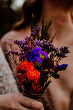 Load image into Gallery viewer, May include: A bouquet of dried flowers with purple, blue, and red blooms. The bouquet is tied with twine and held in a person's hand.
