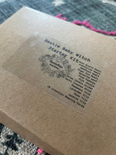 Load image into Gallery viewer, May include: A brown box with a white label that says "Bestie Baby Witch Starter Kit". The label lists various items included in the kit, such as Rose Quartz Heart, Aventurine Heart, Amethyst Heart, Tiger Eye Heart, Selenite Wand, Pink Feather, Pink Candle, Palo Santo Incense Stick, Chime Candle Hol
