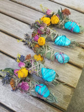 Load image into Gallery viewer, May include: Four bundles of dried sage wrapped in twine, each decorated with yellow and pink dried roses, lavender, and other small wildflowers. A single polished turquoise stone is secured to the front of each bundle with thin wire.
