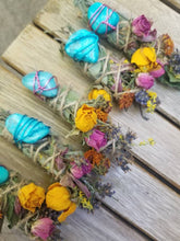 Load image into Gallery viewer, May include: Four bundles of dried sage wrapped in twine, each featuring a bright turquoise stone secured with colored wire. The bundles are decorated with dried yellow and pink rosebuds, orange marigolds, and small sprigs of purple lavender.
