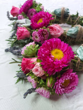 Load image into Gallery viewer, May include: A bouquet of pink and purple flowers with green leaves. The flowers are arranged in a circle and tied together with twine.
