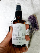 Load image into Gallery viewer, May include: A brown glass bottle with a black spray top and a white label that reads "FACIAL REFRESH Lavender CHARGED AMETHYST CRYSTALS 2 oz / 59 ml".
