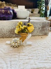 Load image into Gallery viewer, May include: A small plastic troll doll with yellow flowers and dried lavender on its head. The doll is sitting on a white selenite crystal with a pearl and rhinestone brooch next to it.
