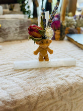 Load image into Gallery viewer, May include: A small, brown troll figurine with a white crystal on its head. The crystal is adorned with dried lavender and a dried rose. The troll is standing on a white selenite stick.
