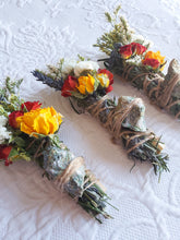 Load image into Gallery viewer, May include: Three bundles of dried flowers and herbs tied with twine, each containing a variety of flowers, including white, yellow, and red roses, and green herbs. The bundles are tied with twine and have a small stone attached to each.
