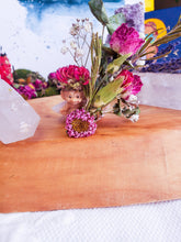 Load image into Gallery viewer, May include: A small, pink and white fairy figurine with a flower crown sits on a wooden surface. The fairy is surrounded by dried flowers, including pink roses, white baby's breath, and green foliage.
