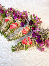 Load image into Gallery viewer, May include: Bundles of dried herbs, roses, and other flowers are wrapped with twine. Some bundles have dried strawberry slices. The flowers are shades of purple, pink, and red. The bundles are arranged on a white, textured surface.
